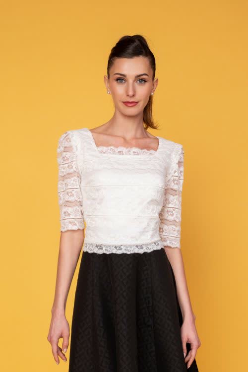 Κοντομάνικο crop top από απαλή ιβουάρ ελαστική δαντέλα, με βολάν στους ώμους και τετράγωνη λαιμόκοψη μπροστά και πίσω σε εφαρμοστή γραμμή, ιδανικό για ψηλόμεσες φούστες.