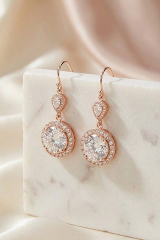 Επίχρυσα rose gold σκουλαρίκια με λαμπερή κεντρική πέτρα και λεπτομέρειες με ζιργκόν περιμετρικά, κατασκευασμένα από ασήμι 925. Ιδανικά για elegant εμφανίσεις με στυλ και λάμψη!