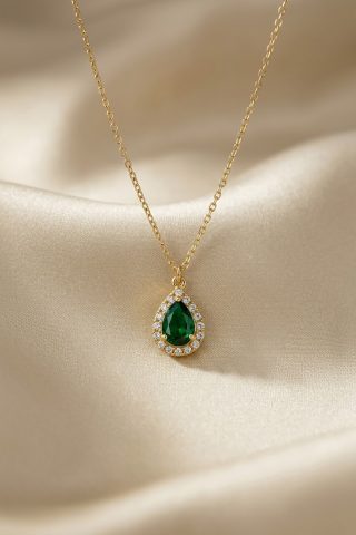 Ένα ντελικάτο κρεμαστό που θυμίζει πολύτιμο εύρημα από άλλη εποχή. Το κεντρικό στοιχείο σε σχήμα δακρύου διαθέτει έναν κρύσταλλο σε βαθύ σμαραγδί χρώμα, ο οποίος πλαισιώνεται από μια σειρά μικρότερων, διάφανων κρυστάλλων που ενισχύουν τη λάμψη του.